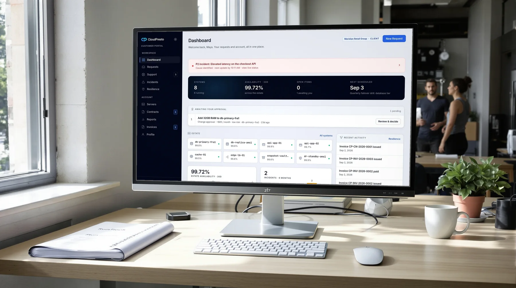 The drill desk: the portal dashboard on screen, the runbook beside the keyboard